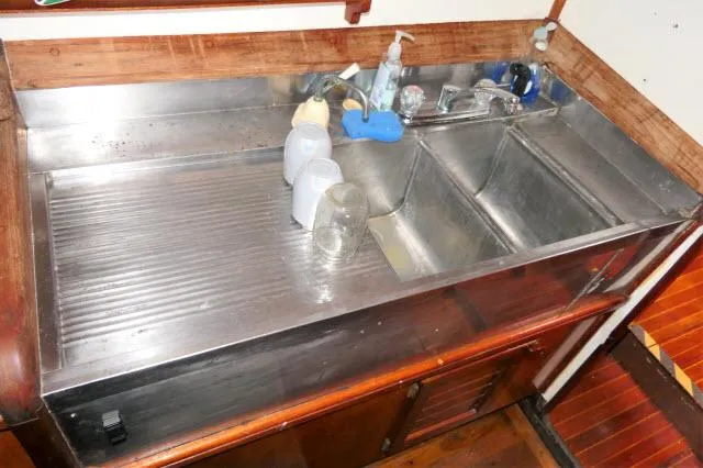 Slide: The Image of 1979 Roberts 54 stainless steel kitchen sink with dual basins and wooden cabinetry. - 12