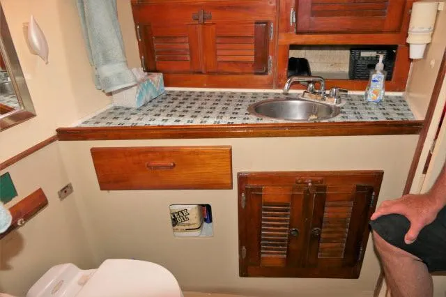 Slide: The Image of 1979 Roberts 54 boat bathroom with wooden cabinets, sink, and tiled countertop. - 27
