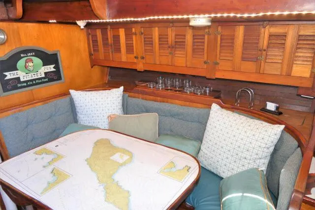 Slide: The Image of 1979 Roberts 54 yacht interior with cozy dining area and nautical map table. - 3