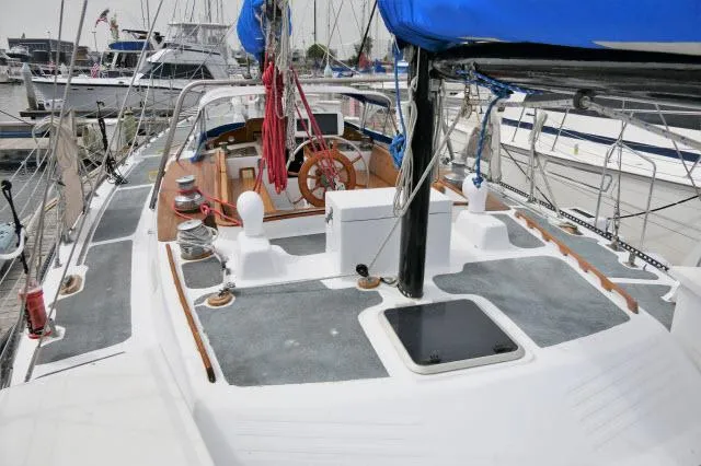 Slide: The Image of 1979 Roberts 54 sailboat deck with blue sail cover, docked at marina. - 41