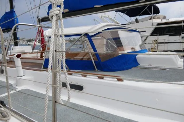 Slide: The Image of 1979 Roberts 54 sailboat with blue canopy docked at marina. - 43