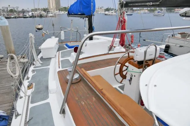 Slide: The Image of 1979 Roberts 54 sailboat deck with wooden accents and marina background. - 45
