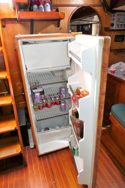 Slide: The Image of Open refrigerator inside a 1979 Roberts 54 boat, stocked with beverages and food. - 7