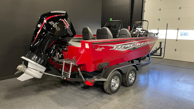 Slide: The Image of 2024 Tracker Targa V-19 Combo boat in a showroom, featuring a powerful engine and sleek design. - 2