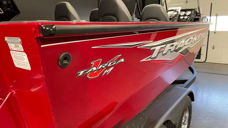 Slide: The Image of 2024 Tracker Targa V-19 Combo boat, red exterior, side view in a showroom. - 4