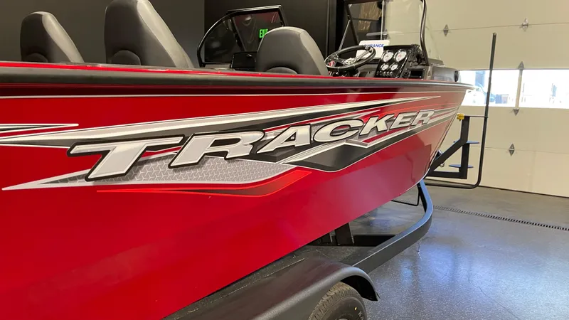 Slide: The Image of 2024 Tracker Targa V-19 Combo boat, red exterior, sleek design, indoor showroom. - 5
