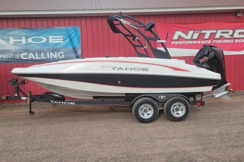 The Image of 2024 Tahoe 1950 boat on trailer, red and white exterior, displayed outdoors. - 0