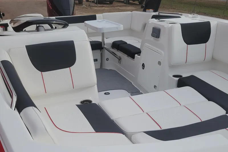 Slide: The Image of 2024 Tahoe 1950 boat interior with white and black seating, red accents, and a small table. - 10