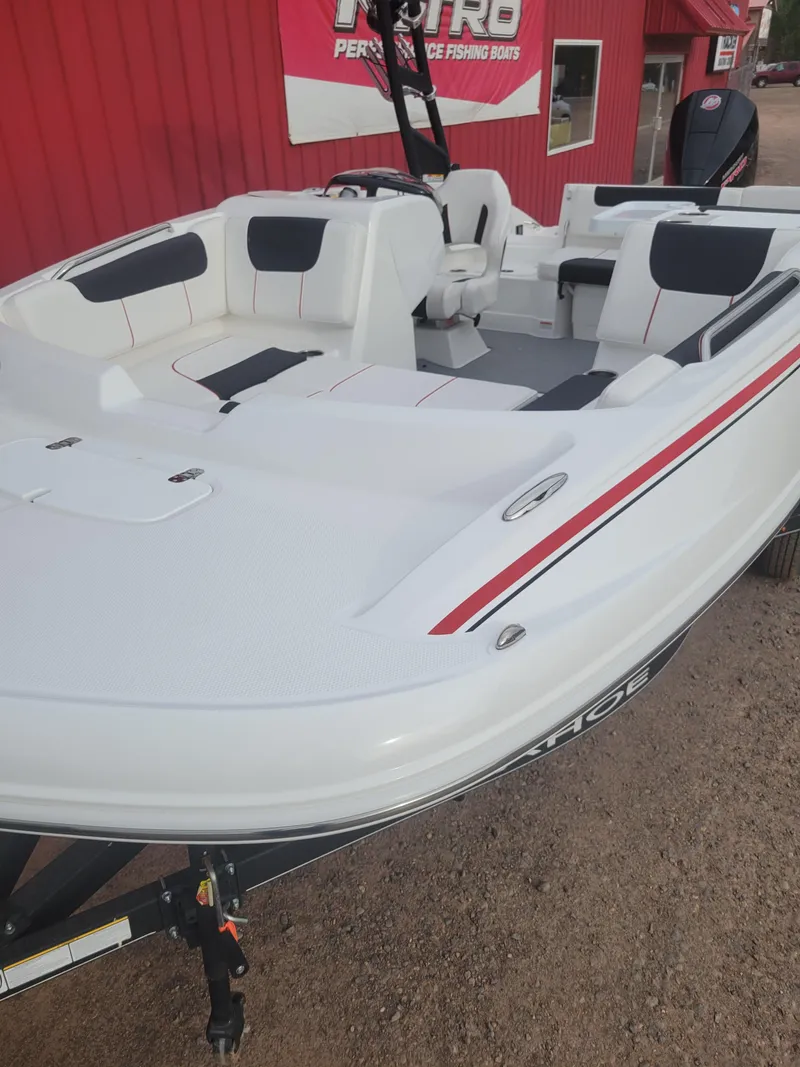 Slide: The Image of 2024 Tahoe 1950 boat with white and black seating, displayed outdoors. - 5