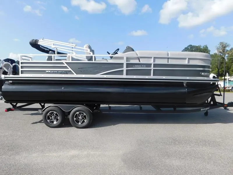 The Image of 2024 Ranger Reata 223FC pontoon boat on a trailer under a blue sky. - 0