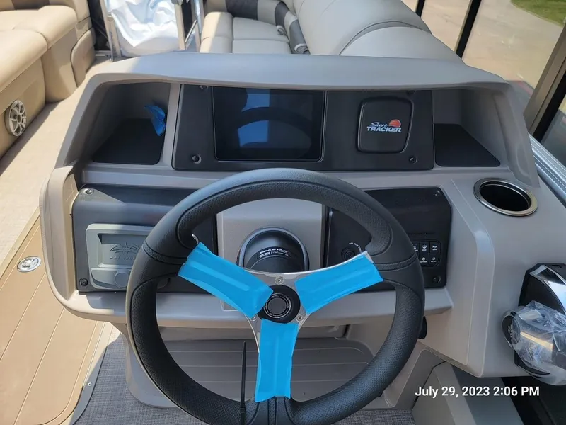Slide: The Image of 2024 Sun Tracker SportFish 22 XP3 boat dashboard with steering wheel and control panel. - 2