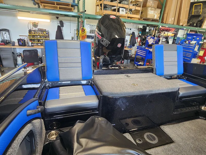 Slide: The Image of 2024 Ranger 1880MS boat interior in workshop, featuring blue and gray seats. - 4