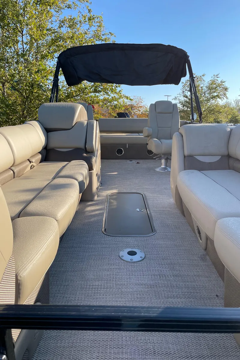 Slide: The Image of 2024 Regency 250 DL3 pontoon boat interior with plush seating and canopy. - 3