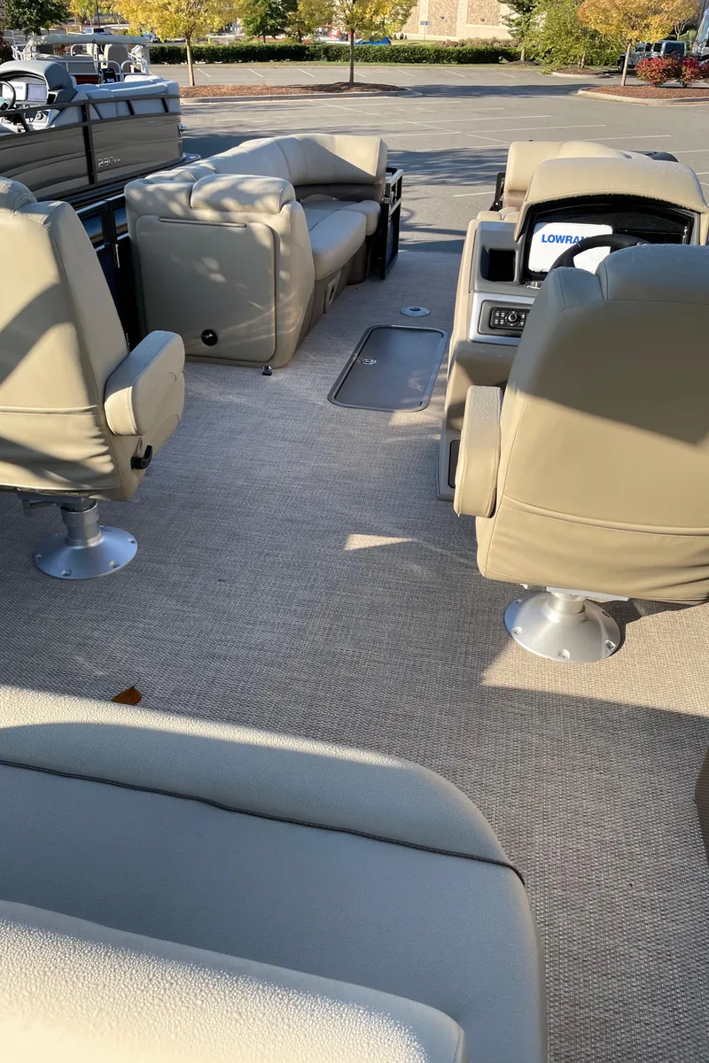 Slide: The Image of 2024 Regency 250 DL3 pontoon boat interior with beige seating and carpet. - 4
