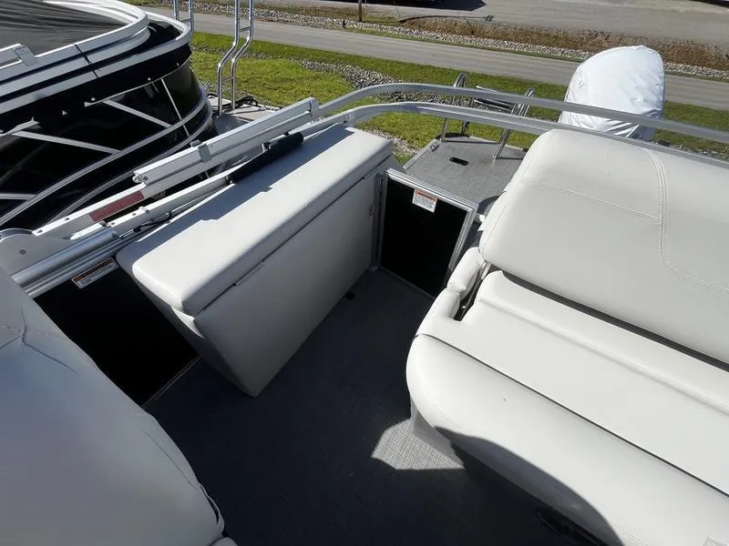 Slide: The Image of 2024 Sylvan Mirage 8522 CLZ boat interior with white seating and storage. - 2