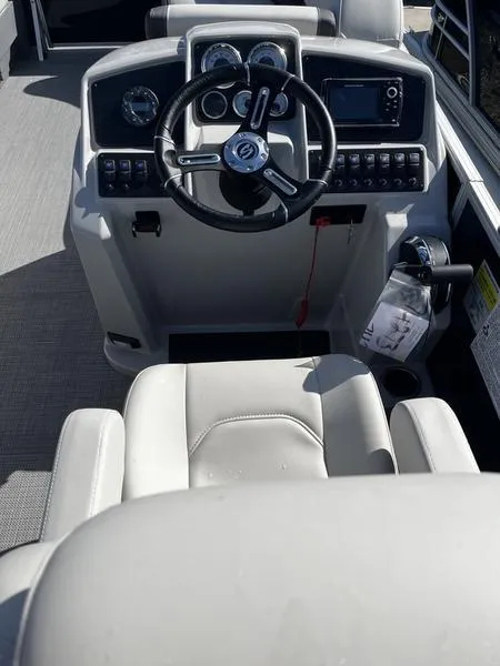 Slide: The Image of 2024 Sylvan Mirage 8522 CLZ boat cockpit with steering wheel and control panel. - 4