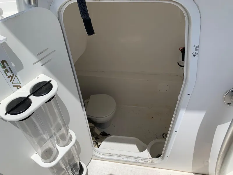 Slide: The Image of 2013 Sea Fox 286 CC boat interior with a small bathroom. - 14