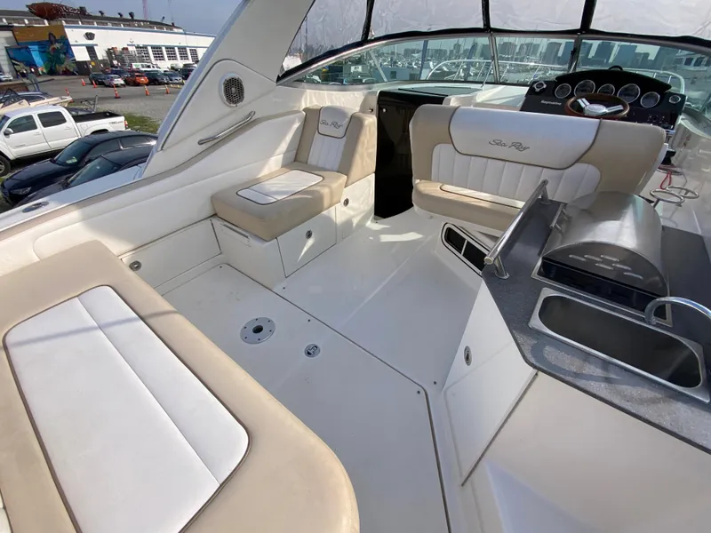 Slide: The Image of 2013 Sea Ray 310 Sundancer boat interior with beige seating and helm. - 1