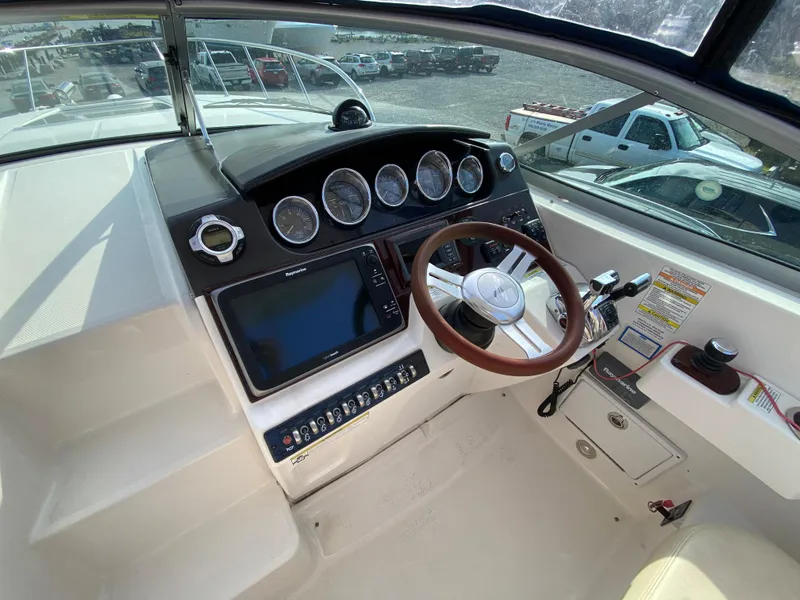 Slide: The Image of 2013 Sea Ray 310 Sundancer helm with steering wheel and navigation controls. - 10