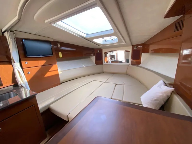 Slide: The Image of Interior of 2013 Sea Ray 310 Sundancer with seating, skylight, and TV. - 14