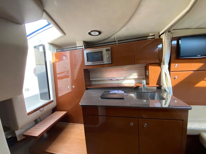 Slide: The Image of Interior of 2013 Sea Ray 310 Sundancer yacht with kitchenette and modern amenities. - 16