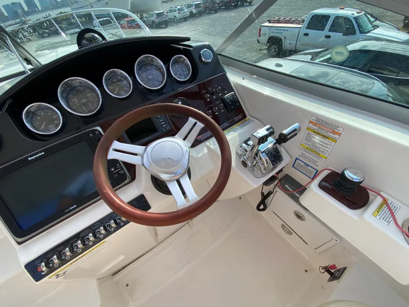 Slide: The Image of Cockpit of 2013 Sea Ray 310 Sundancer with steering wheel and control panel. - 2