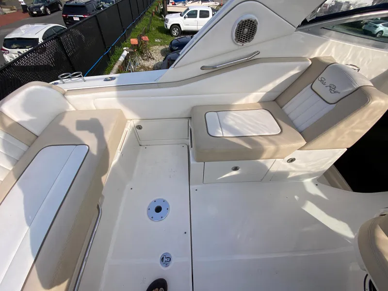 Slide: The Image of 2013 Sea Ray 310 Sundancer boat interior with beige seating and storage compartments. - 9