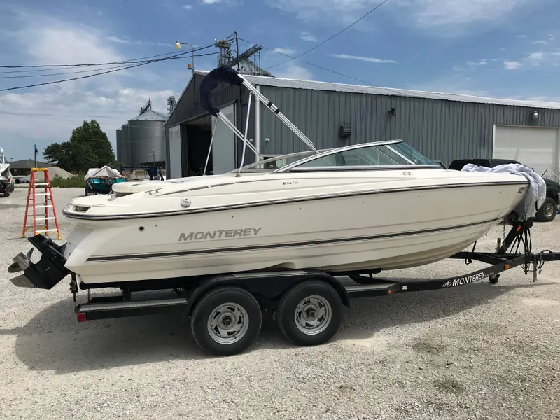 The Image of 2010 Monterey 214FS boat on a trailer outside a warehouse. - 1