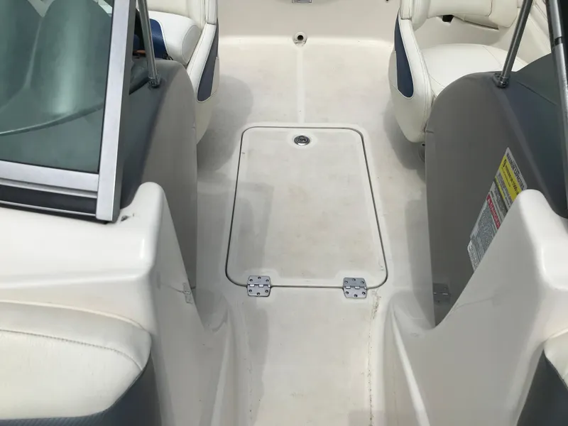 Slide: The Image of 2010 Monterey 214FS boat interior with white seating and storage compartment. - 15
