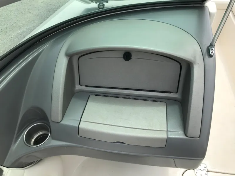 Slide: The Image of 2010 Monterey 214FS boat dashboard with storage compartment and cup holder. - 18