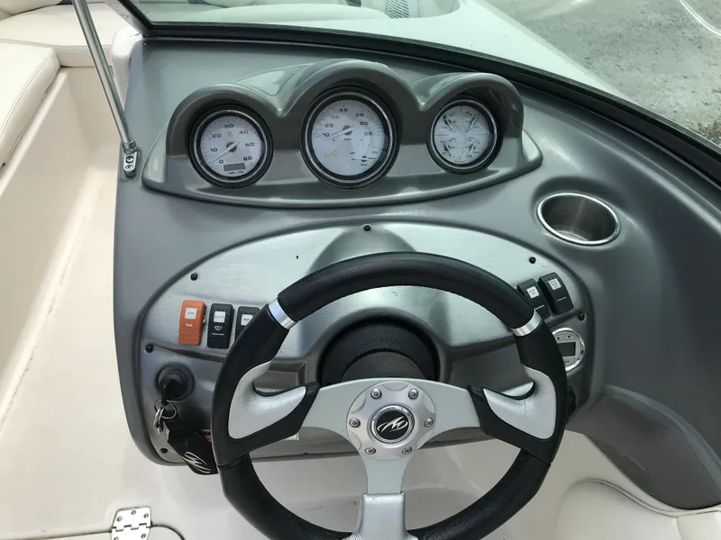 Slide: The Image of 2010 Monterey 214FS boat dashboard with steering wheel and gauges. - 19