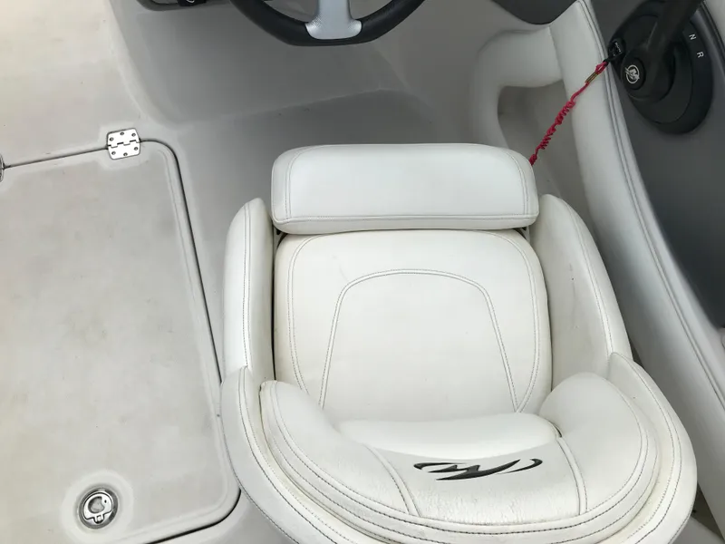 Slide: The Image of 2010 Monterey 214FS boat interior with white captain's seat and steering wheel. - 21