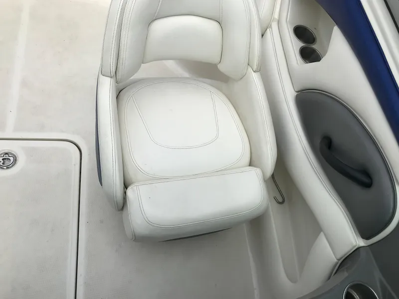 Slide: The Image of 2010 Monterey 214FS boat interior with white leather seat and cup holders. - 22