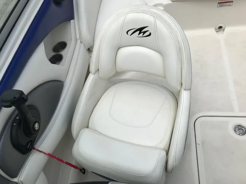 Slide: The Image of 2010 Monterey 214FS boat interior with white captain's chair and control panel. - 23