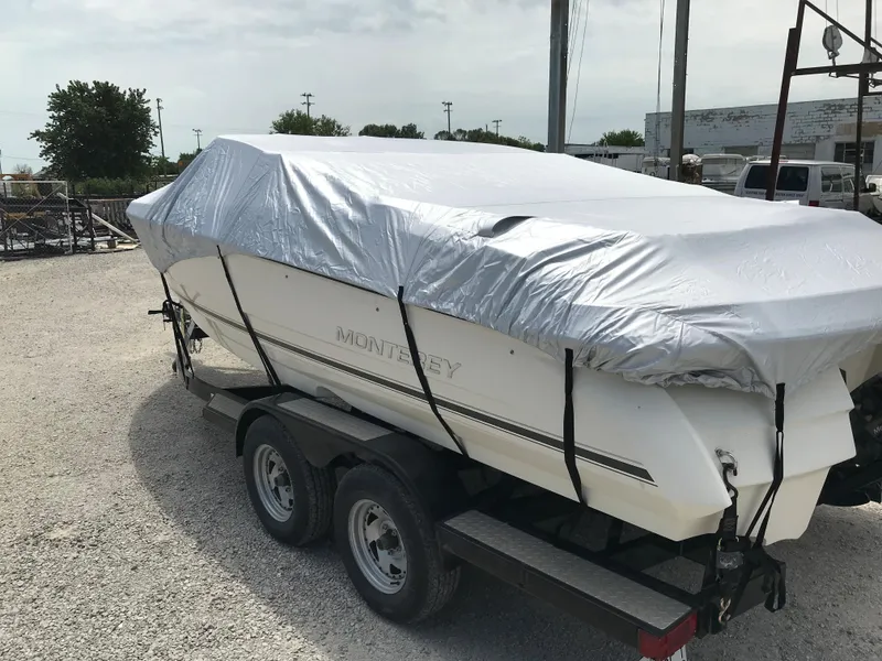 Slide: The Image of 2010 Monterey 214FS boat covered on a trailer in a parking lot. - 30