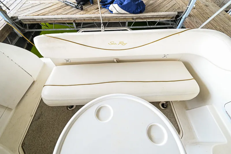 Slide: The Image of 2001 Sea Ray 260 Sundancer boat interior with white seating and table. - 11