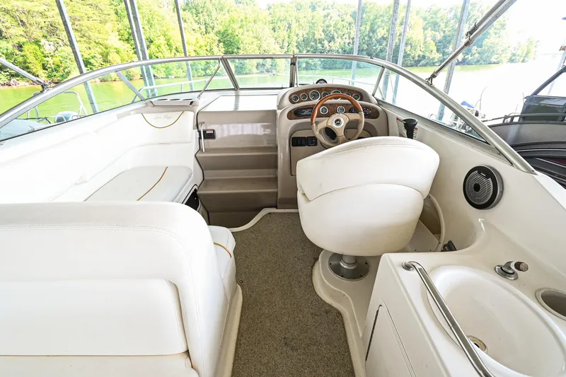 Slide: The Image of 2001 Sea Ray 260 Sundancer boat cockpit with white seating and steering wheel. - 13
