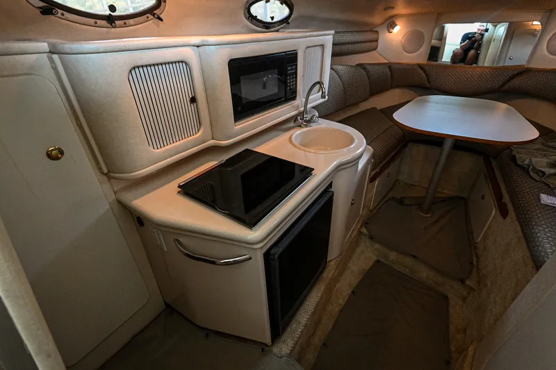 Slide: The Image of Interior of a 2001 Sea Ray 260 Sundancer boat with kitchenette and seating area. - 24