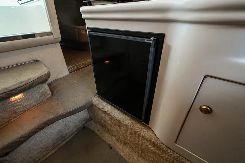 Slide: The Image of 2001 Sea Ray 260 Sundancer cabin interior with mini fridge and carpeted steps. - 26