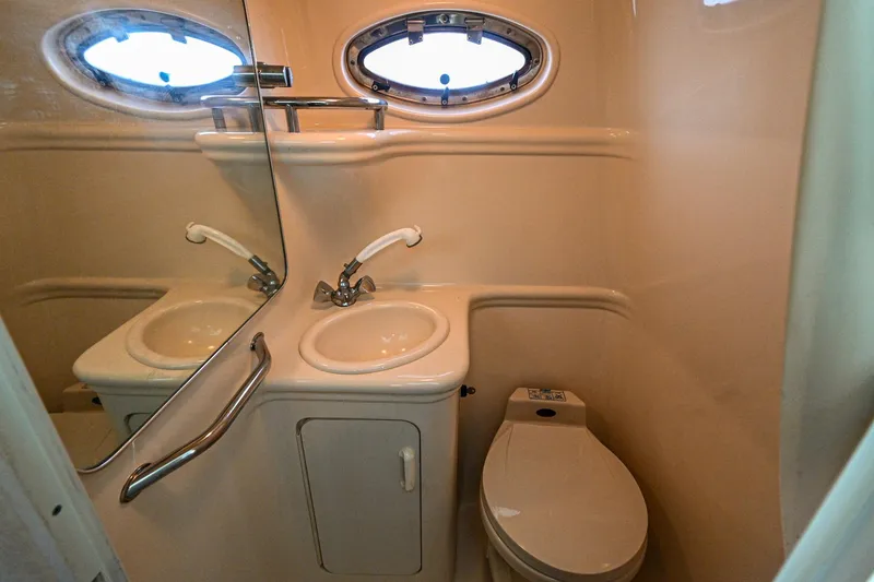 Slide: The Image of Compact bathroom in 2001 Sea Ray 260 Sundancer boat with sink, mirror, and toilet. - 33