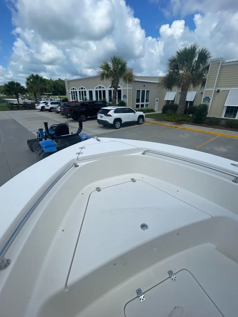 Slide: The Image of 2021 Bulls Bay 200 CC boat parked in a lot with palm trees and buildings. - 18