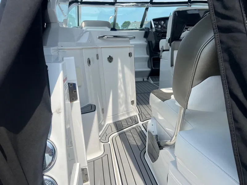 Slide: The Image of Interior of a 2019 Monterey 295 Sport Yacht with white seating and modern dashboard. - 11