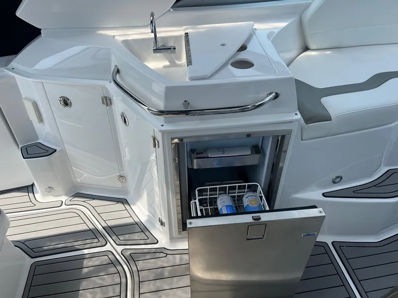 Slide: The Image of 2019 Monterey 295 Sport Yacht kitchenette with sink and mini fridge. - 14