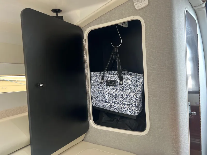 Slide: The Image of Storage compartment inside 2019 Monterey 295 Sport Yacht with patterned bag. - 15