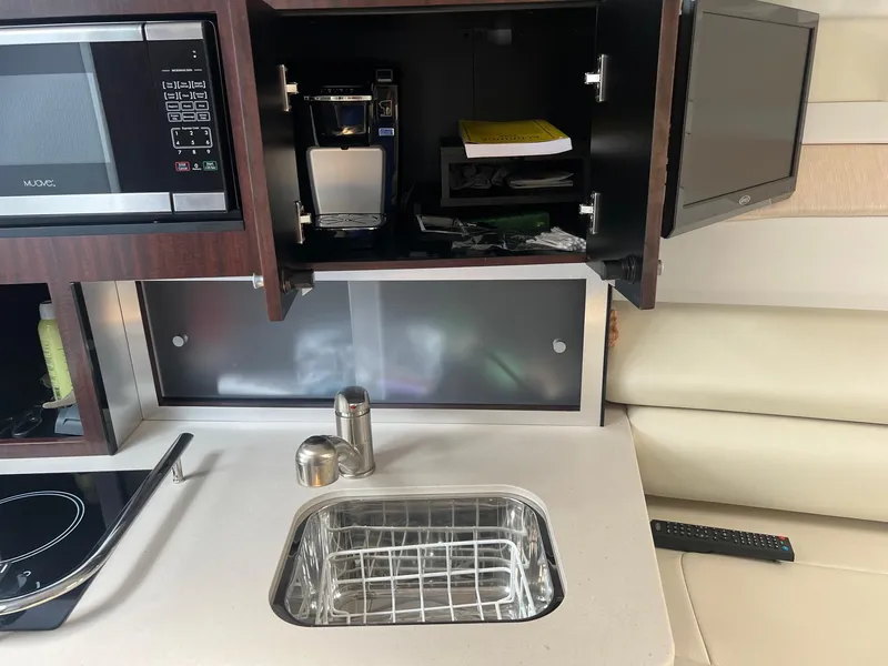 Slide: The Image of 2019 Monterey 295 Sport Yacht kitchen area with sink, microwave, and coffee maker. - 16