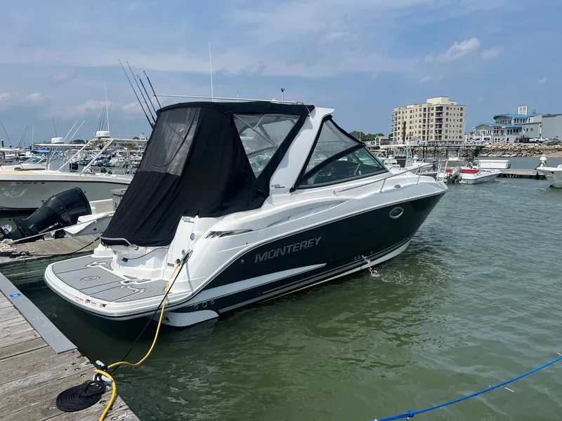 Slide: The Image of 2019 Monterey 295 Sport Yacht docked at a marina. - 2