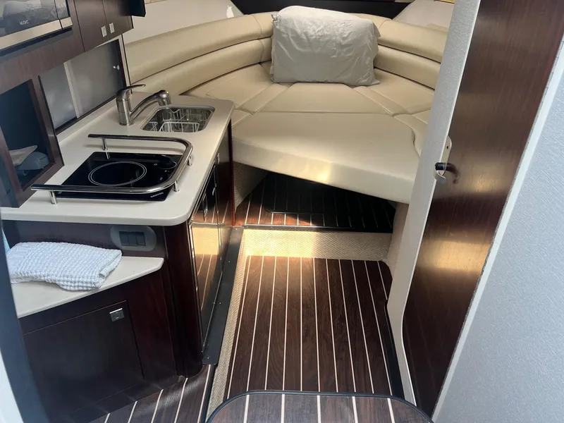 Slide: The Image of 2019 Monterey 295 Sport Yacht interior with kitchenette and seating area. - 24