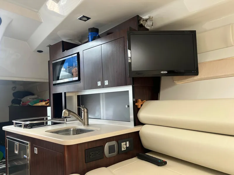 Slide: The Image of Interior of 2019 Monterey 295 Sport Yacht with kitchenette, TV, and seating area. - 30