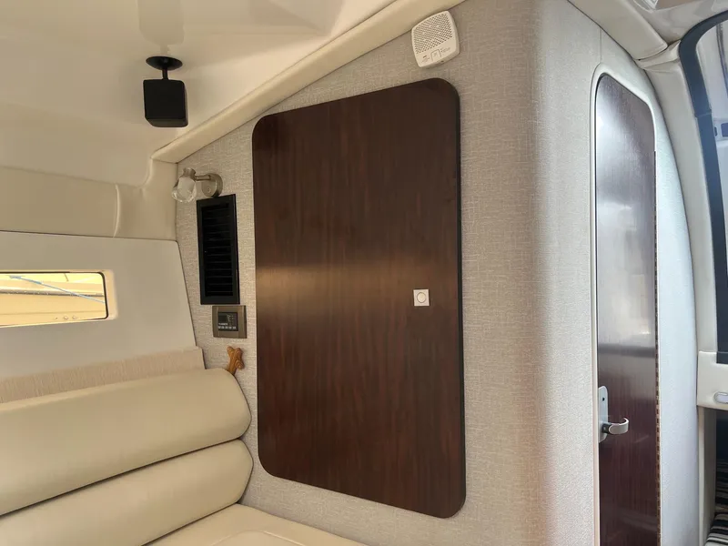 Slide: The Image of Interior of 2019 Monterey 295 Sport Yacht with beige seating and wooden paneling. - 31