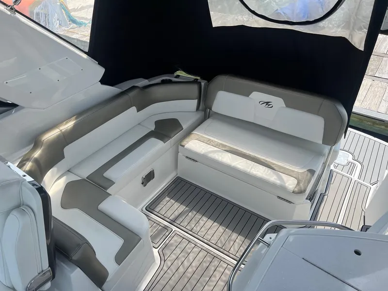 Slide: The Image of 2019 Monterey 295 Sport Yacht interior seating area with white and gray upholstery. - 8